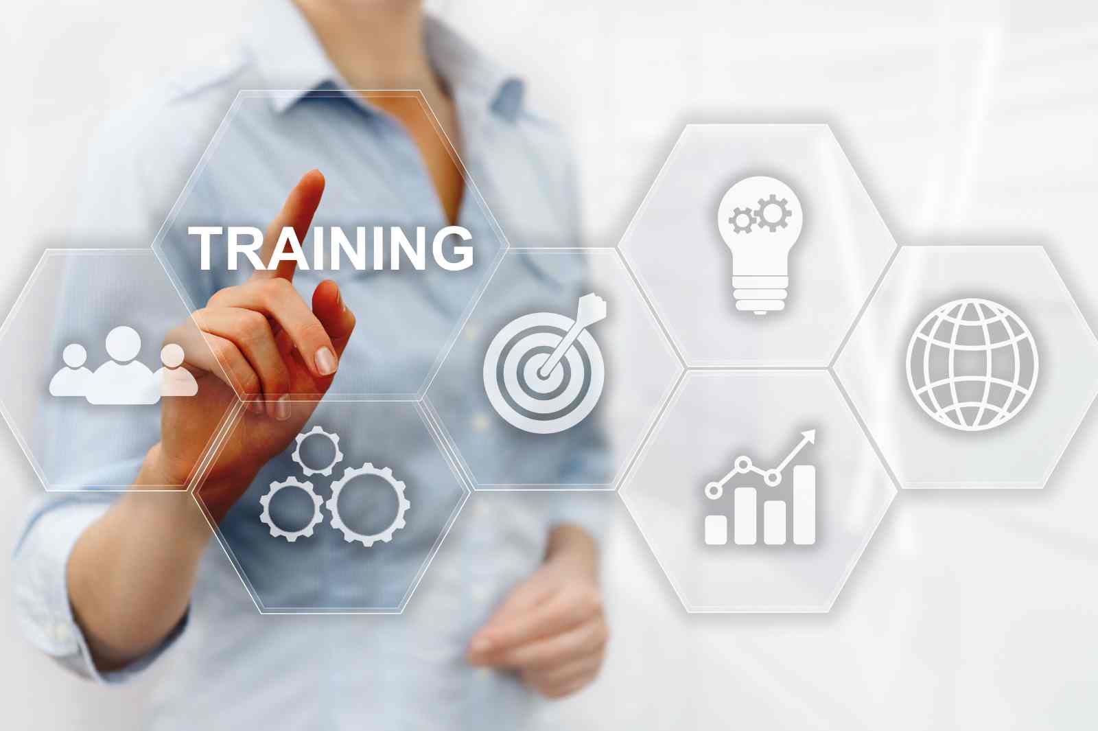 A person points at a digital "Training" icon surrounded by business symbols.