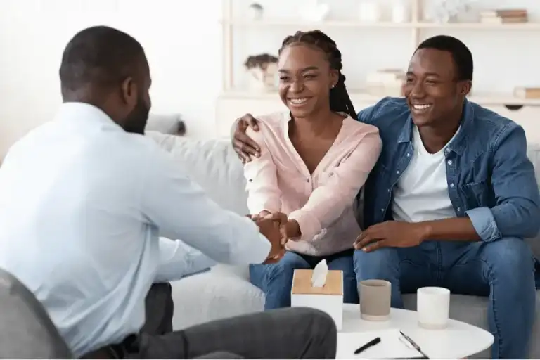 Happy couple smiling and shaking hands during marriage therapy